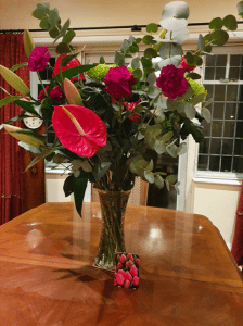 Red bunch of flowers in a vase on a table | 1 Dog At a Time Rescue UK